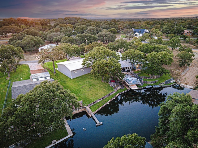 aerial view at dusk featuring a water view