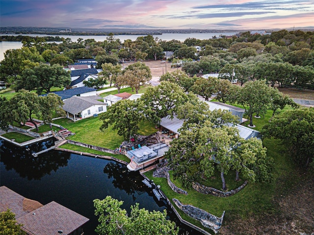 aerial view at dusk featuring a water view