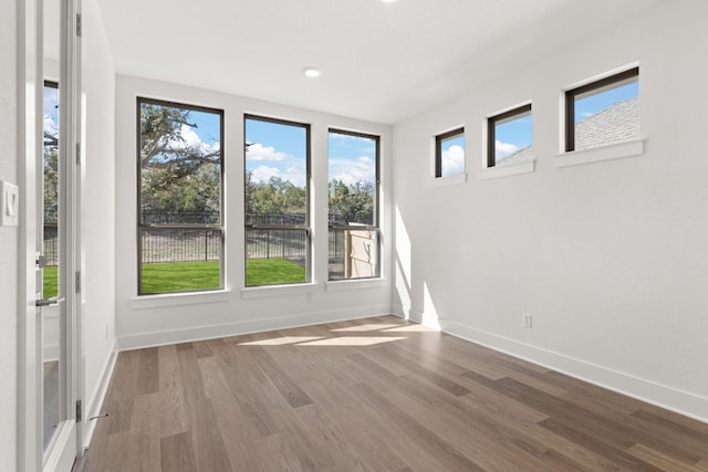 unfurnished room with hardwood / wood-style flooring and a wealth of natural light