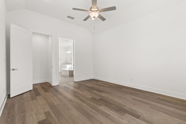 unfurnished bedroom with vaulted ceiling, ensuite bathroom, ceiling fan, and dark hardwood / wood-style flooring