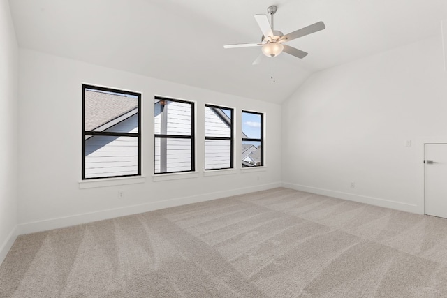 carpeted spare room featuring lofted ceiling and ceiling fan