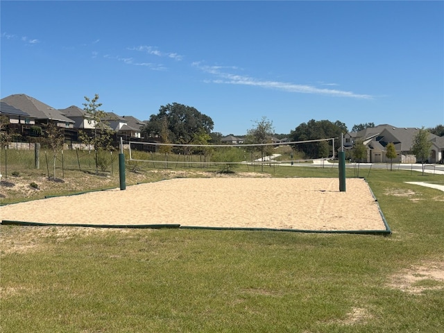 view of home's community featuring volleyball court and a lawn