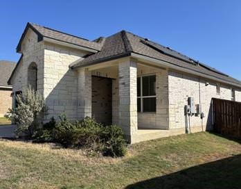 view of side of home with a lawn