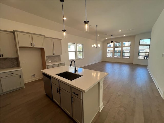 kitchen with a kitchen island with sink, sink, stainless steel dishwasher, and gray cabinetry