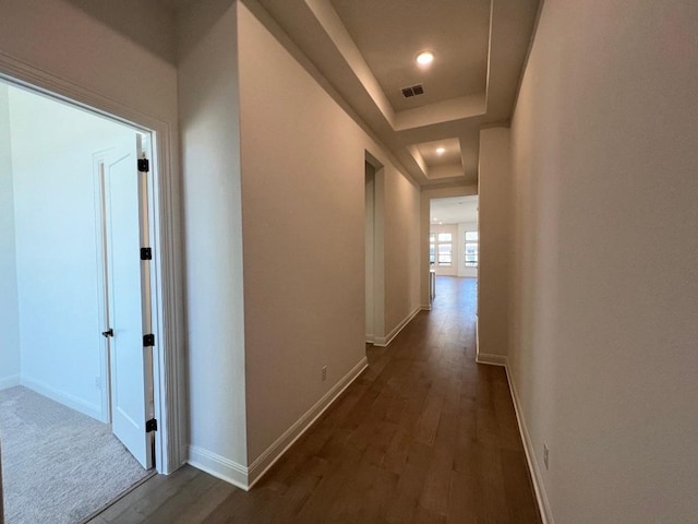 hallway featuring dark hardwood / wood-style floors and a raised ceiling