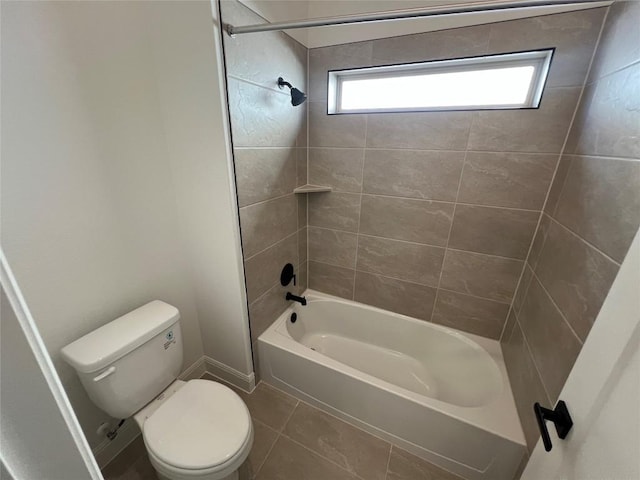 bathroom featuring tile patterned floors, toilet, and tiled shower / bath