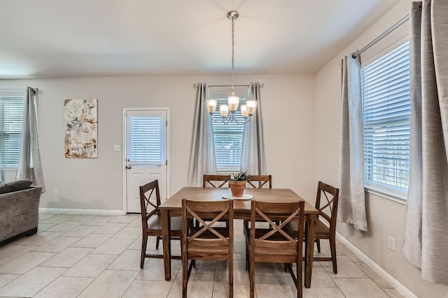 tiled dining room featuring a chandelier