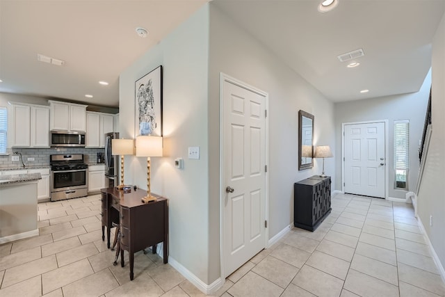 hallway featuring light tile patterned floors and sink