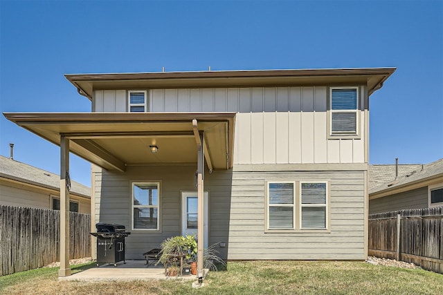 rear view of property with a yard and a patio area