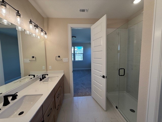 bathroom with vanity and a shower with shower door