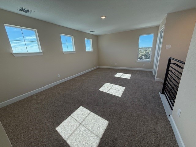 spare room featuring dark colored carpet