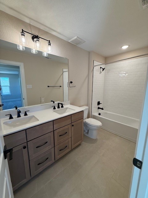 552 Raleigh Dr, Georgetown, TX 78633 - full bathroom with double vanity, toilet,  shower combination, and a textured ceiling