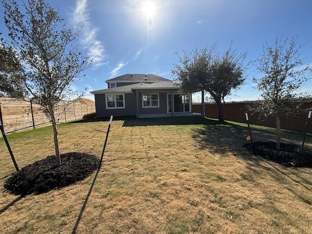 back of property featuring a patio area and a yard