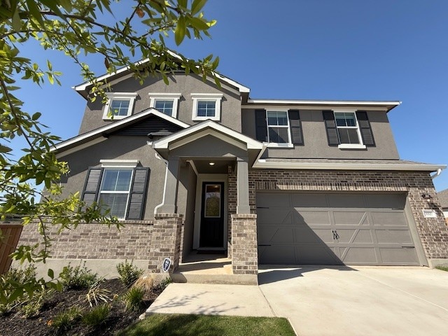552 Raleigh Dr, Georgetown, TX 78633 - view of front facade with stucco siding, driveway, an attached garage, and brick siding