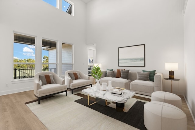 living room with a towering ceiling and light hardwood / wood-style floors