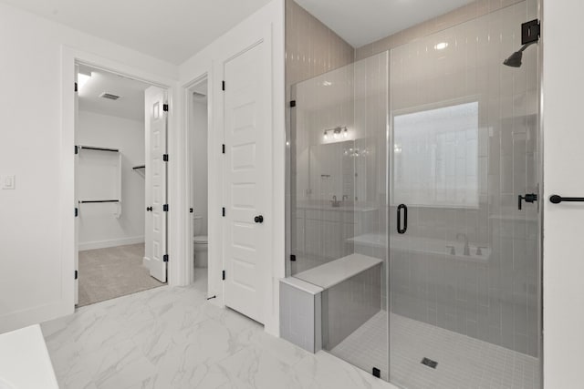 bathroom with toilet and a shower with shower door