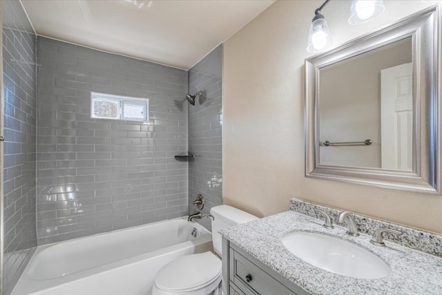 full bathroom featuring tiled shower / bath combo, vanity, and toilet