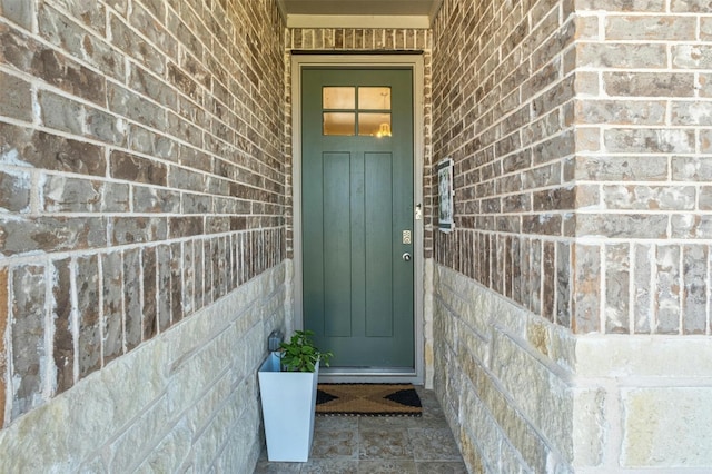 property entrance featuring brick siding