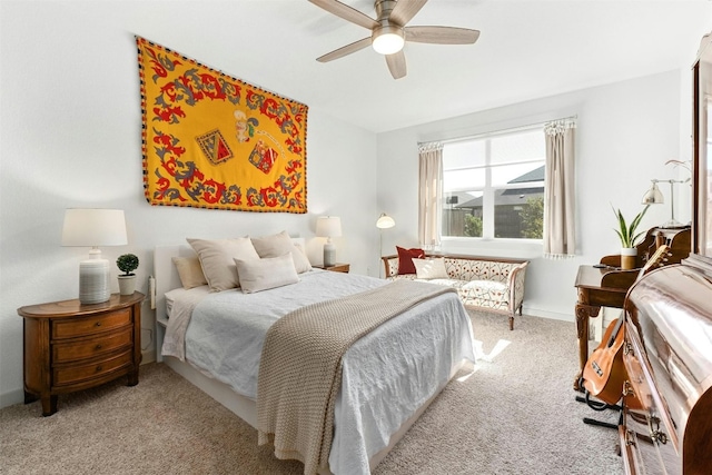 bedroom featuring light carpet, a ceiling fan, and baseboards