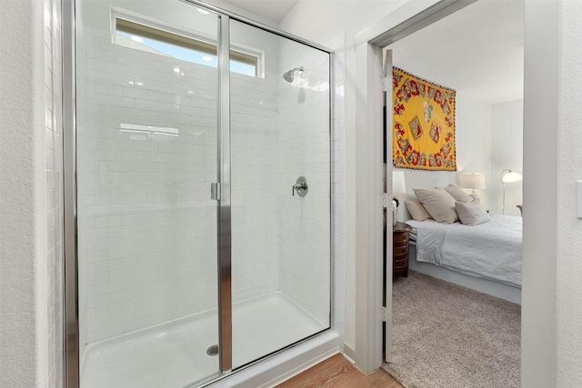 ensuite bathroom featuring ensuite bath and a shower stall