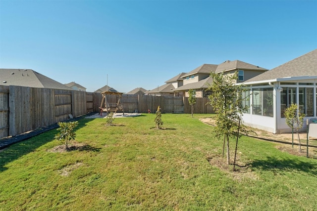 view of yard featuring a fenced backyard and a sunroom