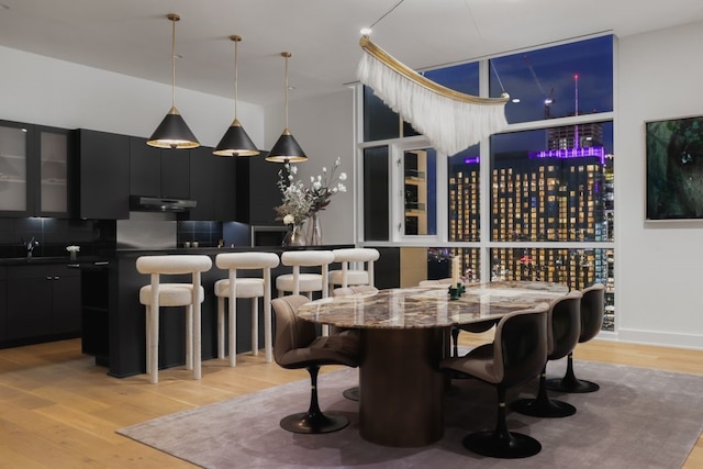 dining room featuring light wood-type flooring and bar area