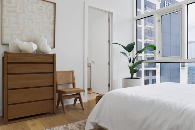 bedroom featuring multiple windows and light hardwood / wood-style flooring