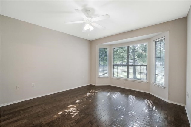 spare room with ceiling fan and dark hardwood / wood-style floors