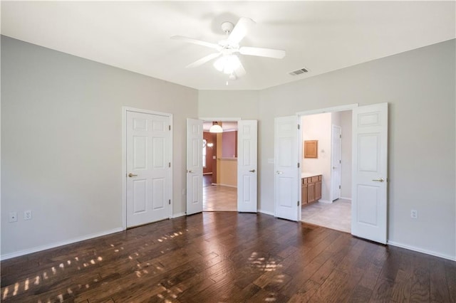 unfurnished bedroom with ensuite bath and dark hardwood / wood-style floors