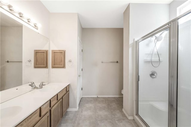 bathroom featuring tile patterned flooring, vanity, a shower with door, and toilet