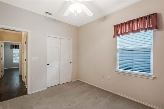 unfurnished bedroom with carpet, ceiling fan, and a closet