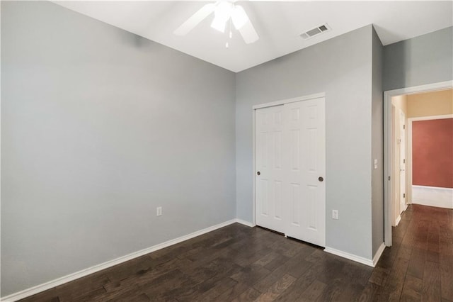 unfurnished bedroom featuring dark wood-type flooring, a closet, and ceiling fan