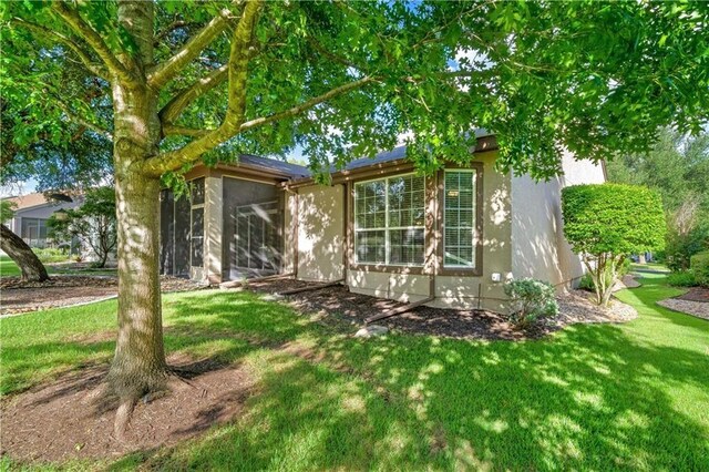 view of front of home with a sunroom and a front lawn