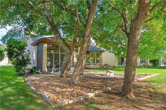 rear view of house with a sunroom and a yard