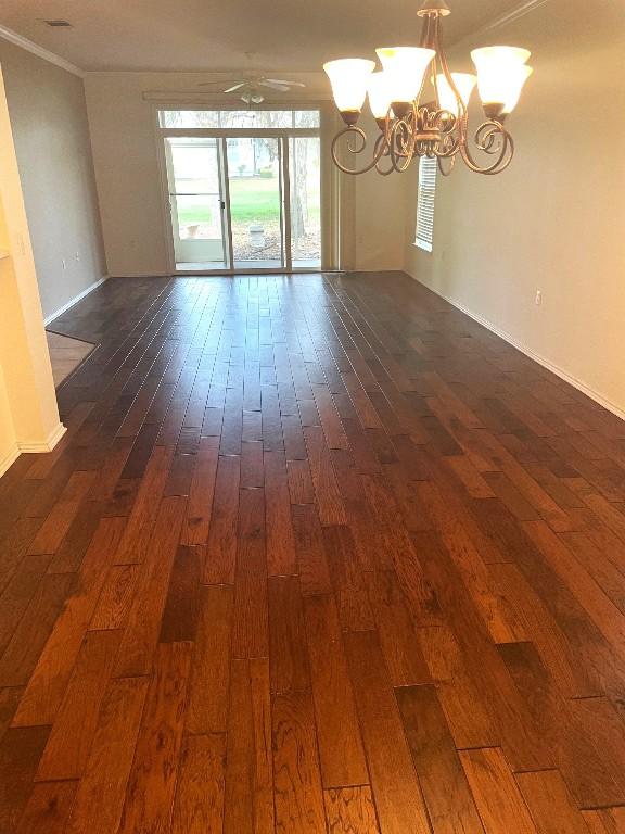 unfurnished room with ornamental molding, dark hardwood / wood-style floors, and ceiling fan with notable chandelier