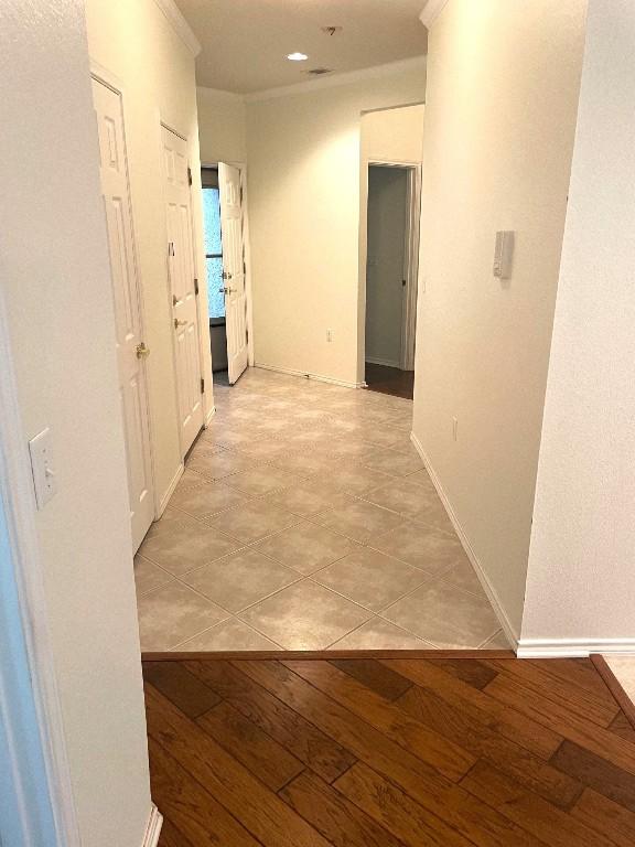 hall featuring crown molding and light hardwood / wood-style floors