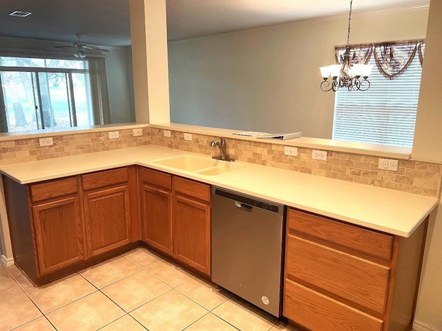 kitchen featuring sink, light tile patterned floors, stainless steel dishwasher, pendant lighting, and backsplash