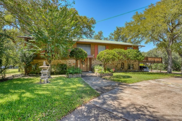 bi-level home featuring a front yard and a wooden deck