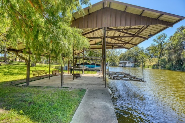 view of dock with a lawn and a water view