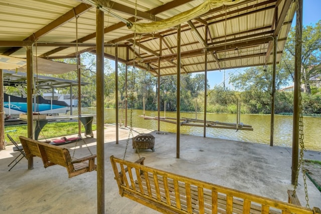 exterior space with a patio, a water view, and an outdoor fire pit