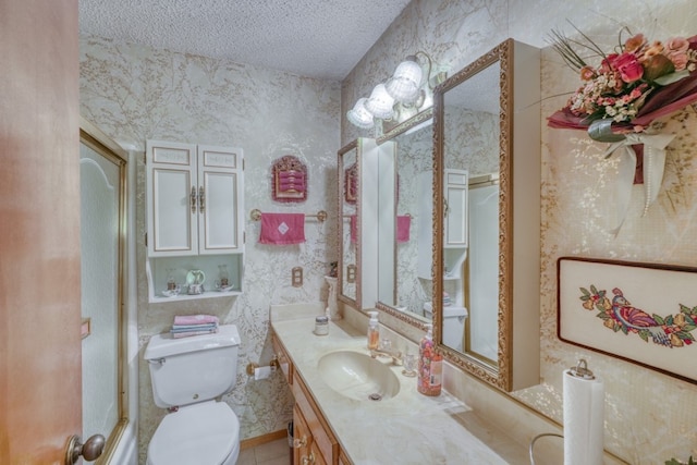 bathroom featuring a shower with door, vanity, toilet, and a textured ceiling