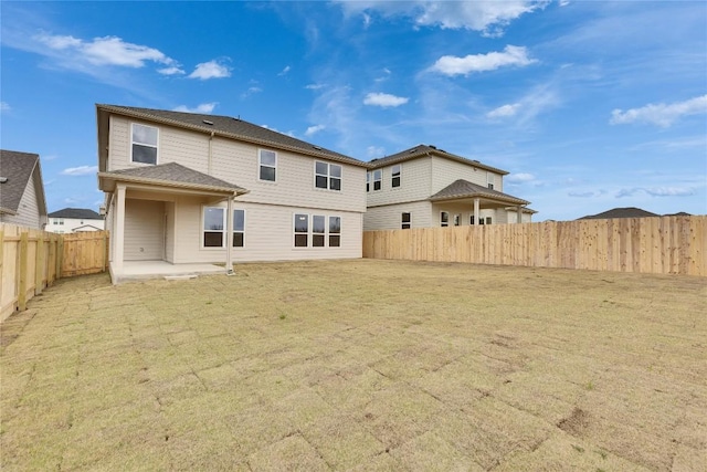 back of property featuring a yard, a fenced backyard, and a patio area