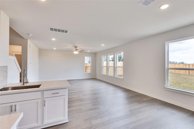 kitchen featuring a sink, visible vents, white cabinets, and light countertops