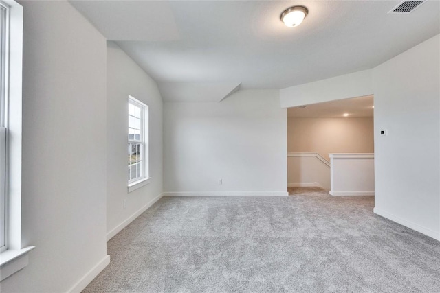 carpeted empty room featuring visible vents and baseboards