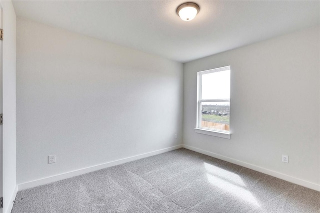 unfurnished room featuring carpet flooring and baseboards