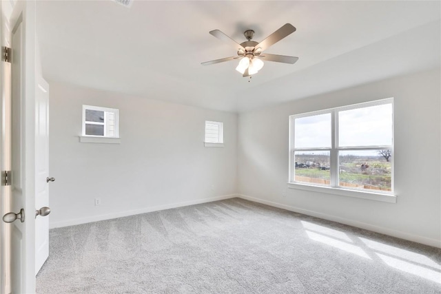 carpeted spare room featuring ceiling fan and baseboards