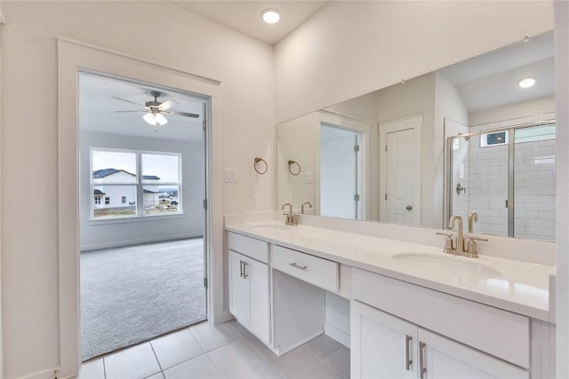 full bathroom with double vanity, tile patterned flooring, a shower stall, and a sink