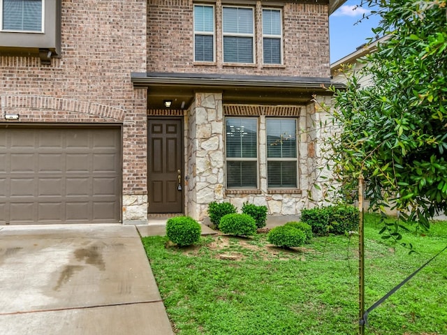 property entrance with a garage and a lawn