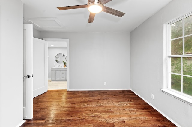 spare room with ceiling fan, sink, hardwood / wood-style floors, and a healthy amount of sunlight