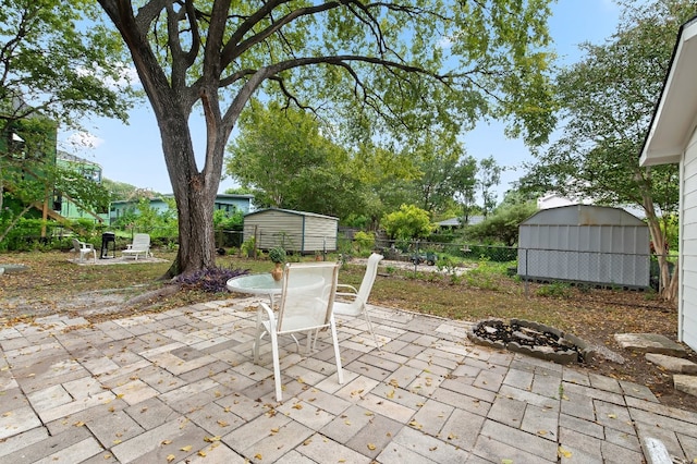 view of patio / terrace featuring a shed and an outdoor fire pit